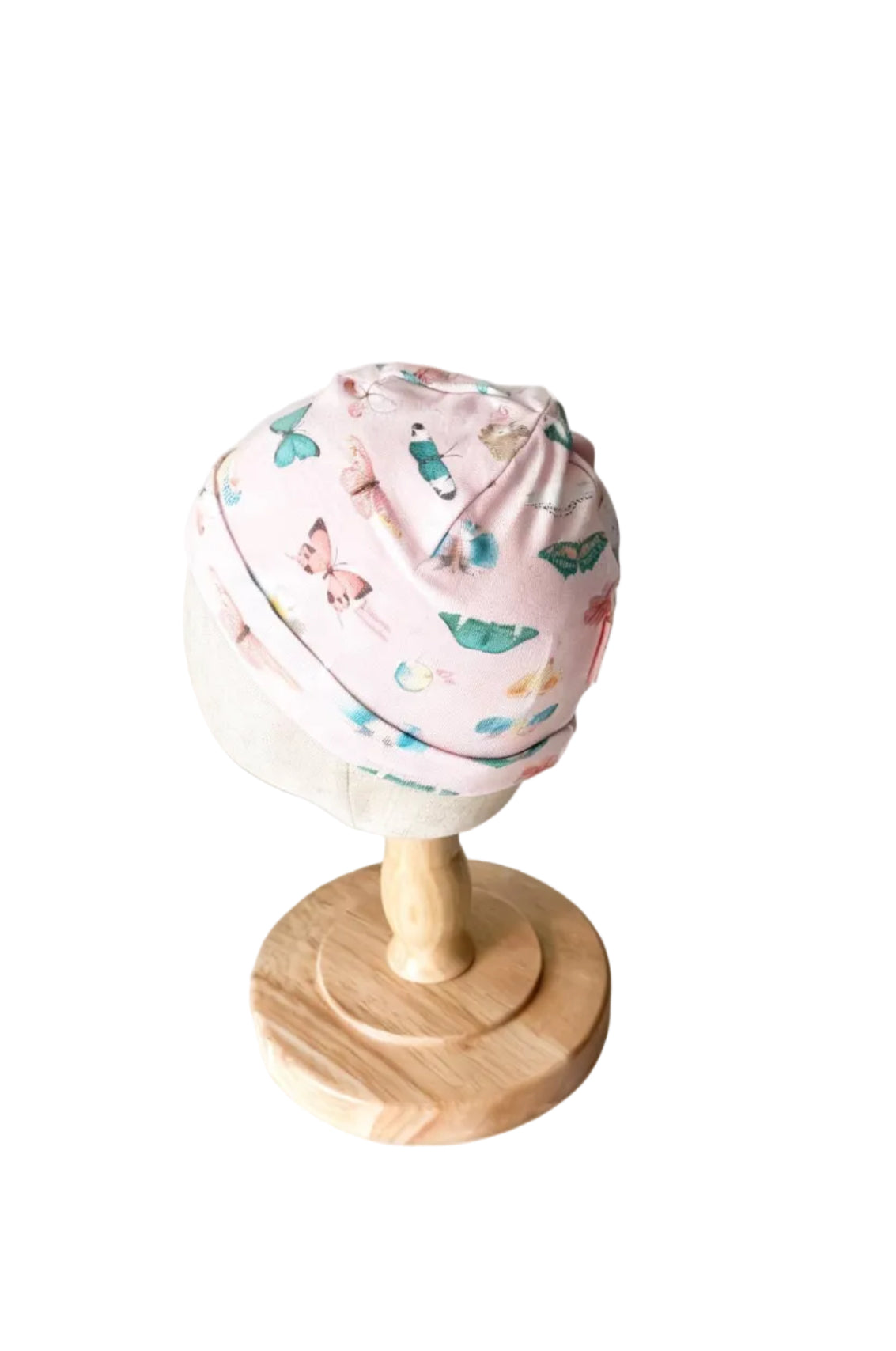 Bonnet bébé rose crème à motifs d’oiseaux et papillons, vue latérale.