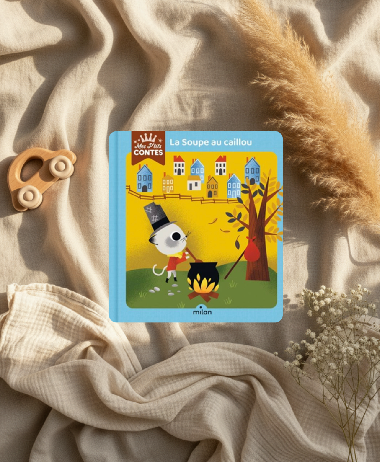 Livre jeunesse La Soupe au caillou, couverture jaune avec maisons et animal mignon.