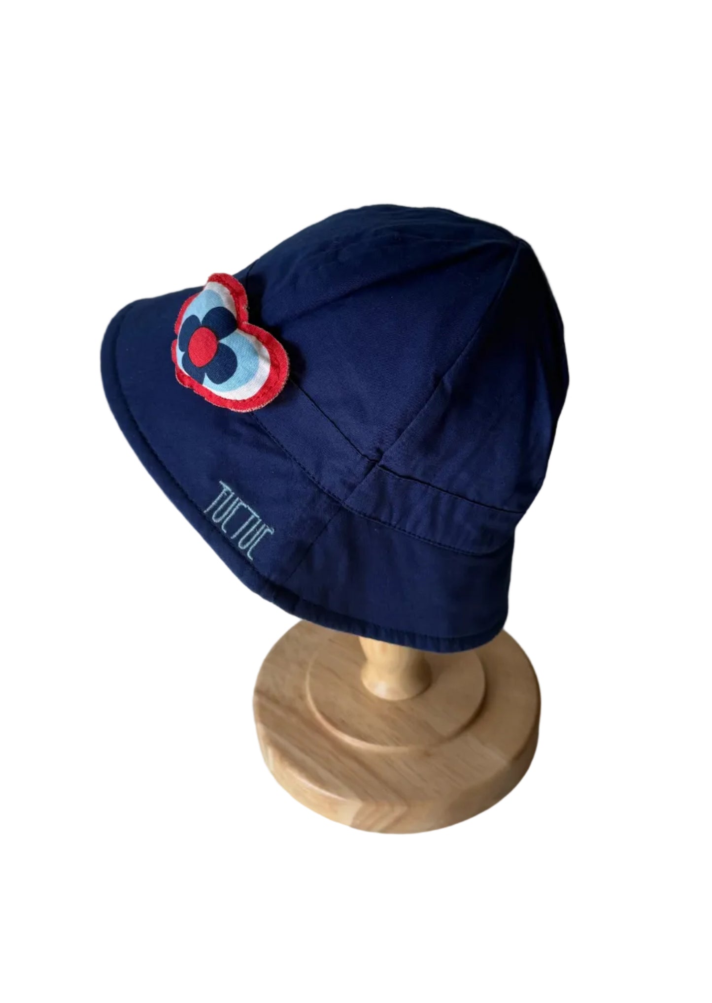 Chapeau bébé bleu avec appliqué cœur multicolore sur le côté et inscription TUTIU.