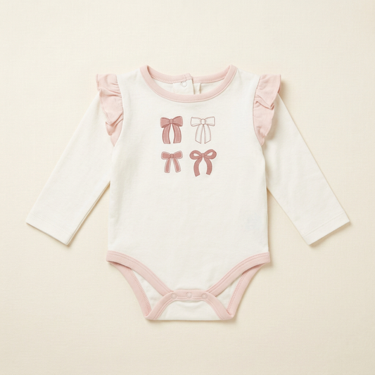 Body bébé ChickPea blanc à manches longues, col et bords roses, motif nœuds