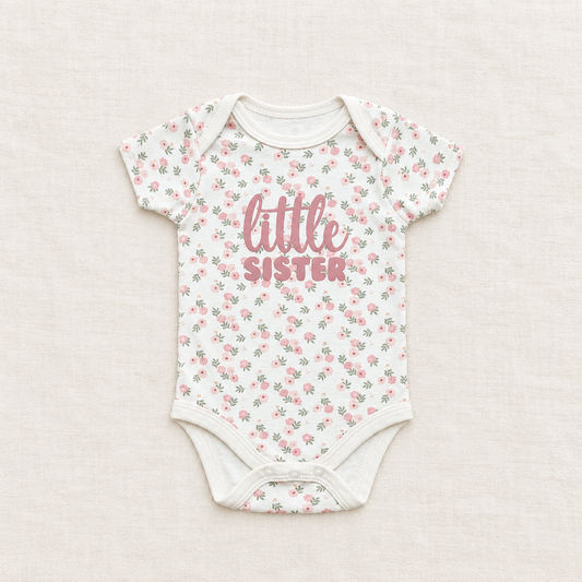 Body bébé manches courtes à fleurs blanches, inscription « little sister » au centre