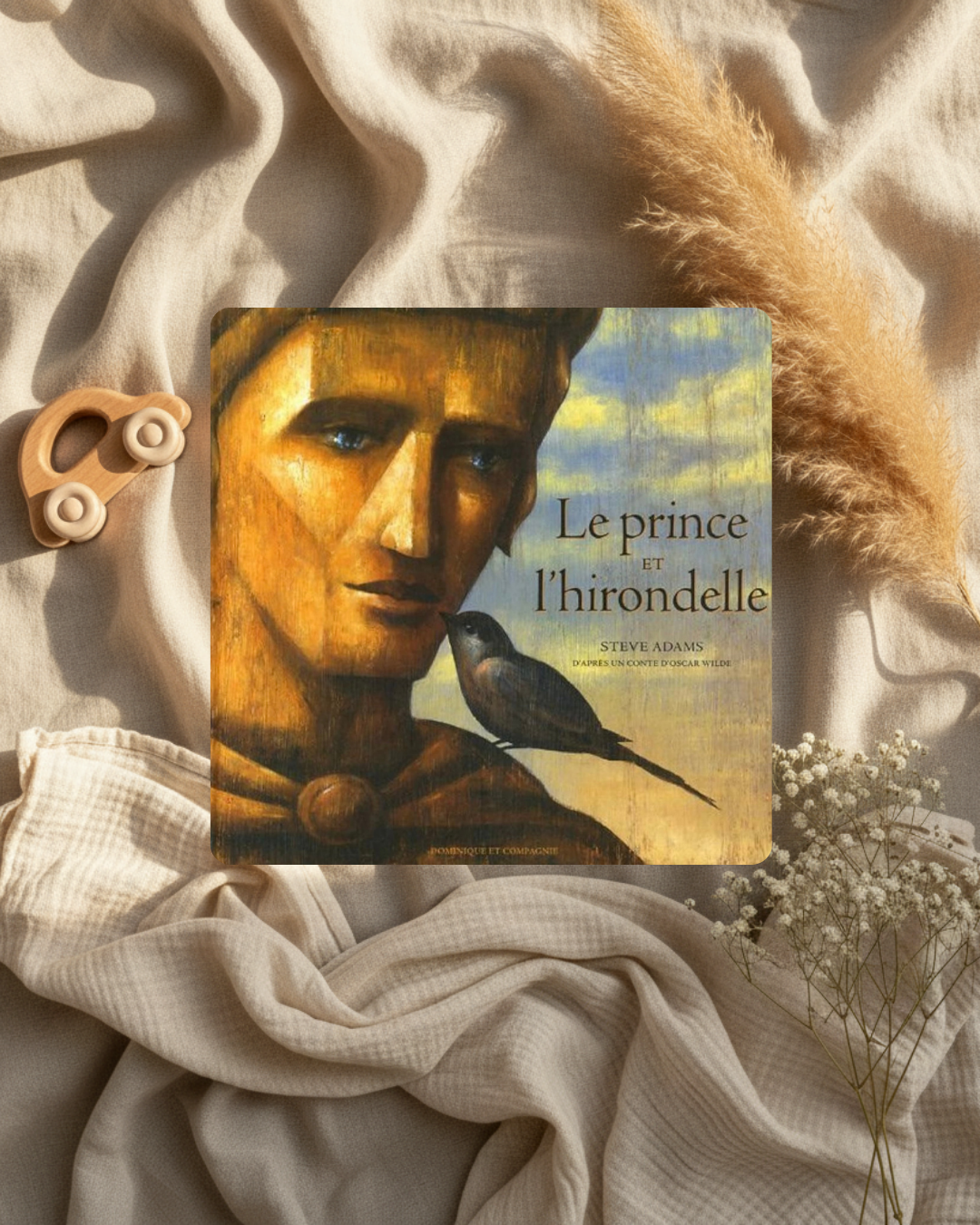 Livre à couverture illustrée : visage doré et oiseau, texte « Le prince et l’hirondelle »