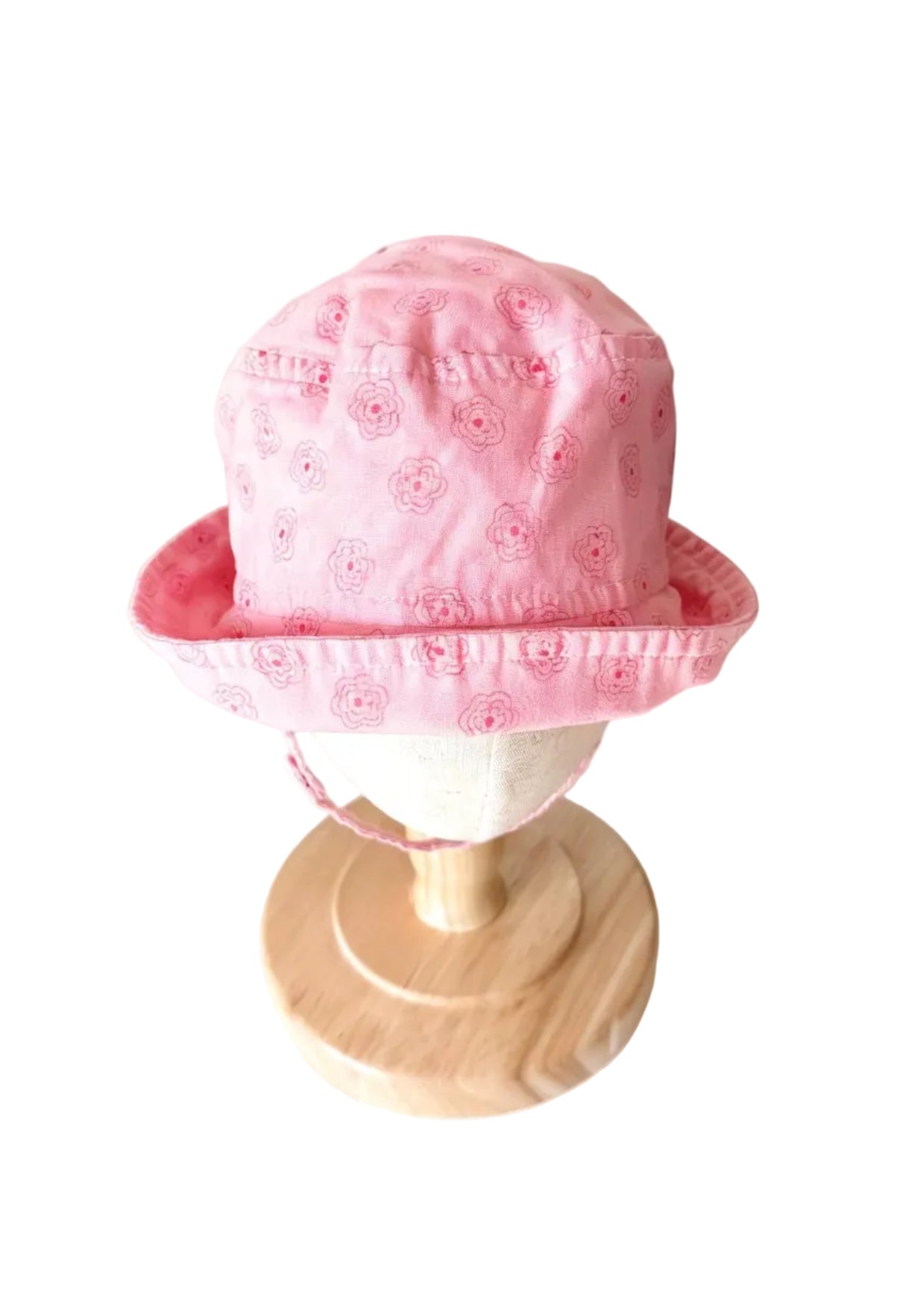 Chapeau bébé rose à motifs fleuris, bord cloche, tour de tête ajustable.