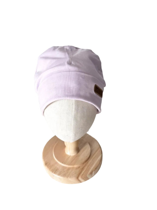 Bonnet bébé en tissu lilas, revers côtelé et étiquette patch sur le côté.