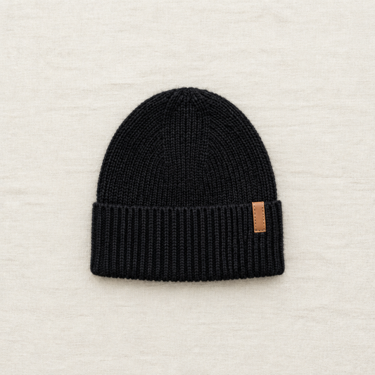 Tuque Deux par Deux noire, bord côtelé et petit écusson en cuir sur le revers.
