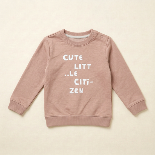 Chandail bébé à manches longues beige rosé, col rond côtelé, imprimé texte.