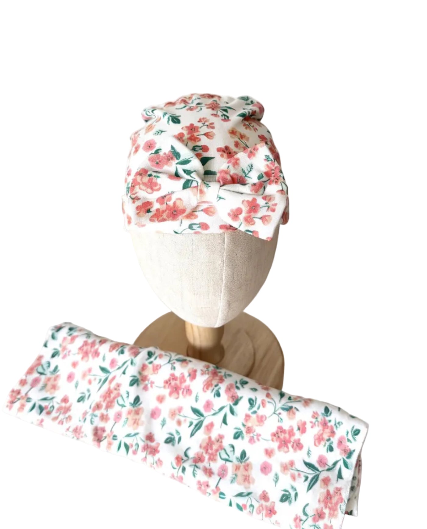Bonnet à fleurs avec nœud, blanc à motifs roses et verts.