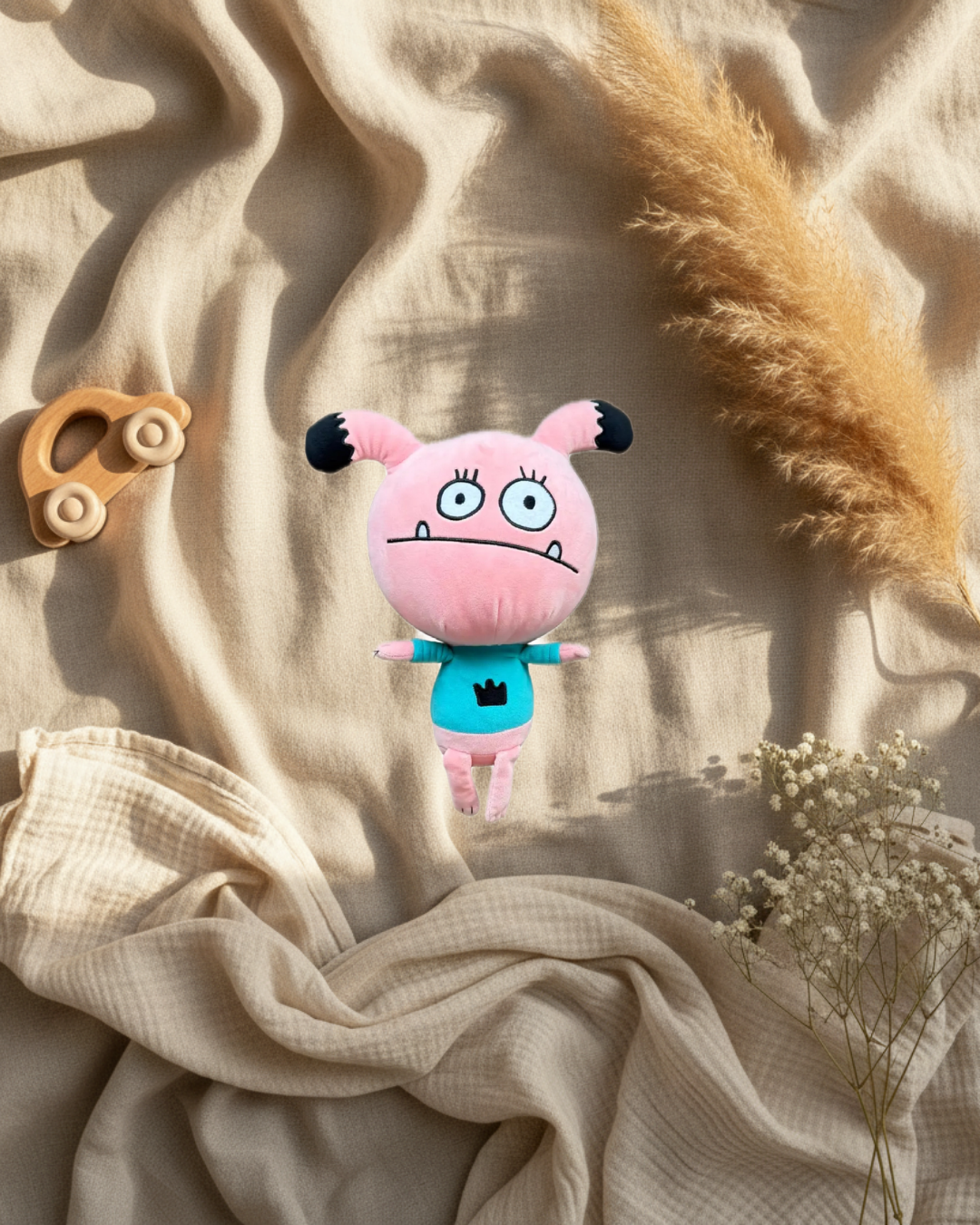Peluche monstre rose, chemise turquoise, grand visage souriant