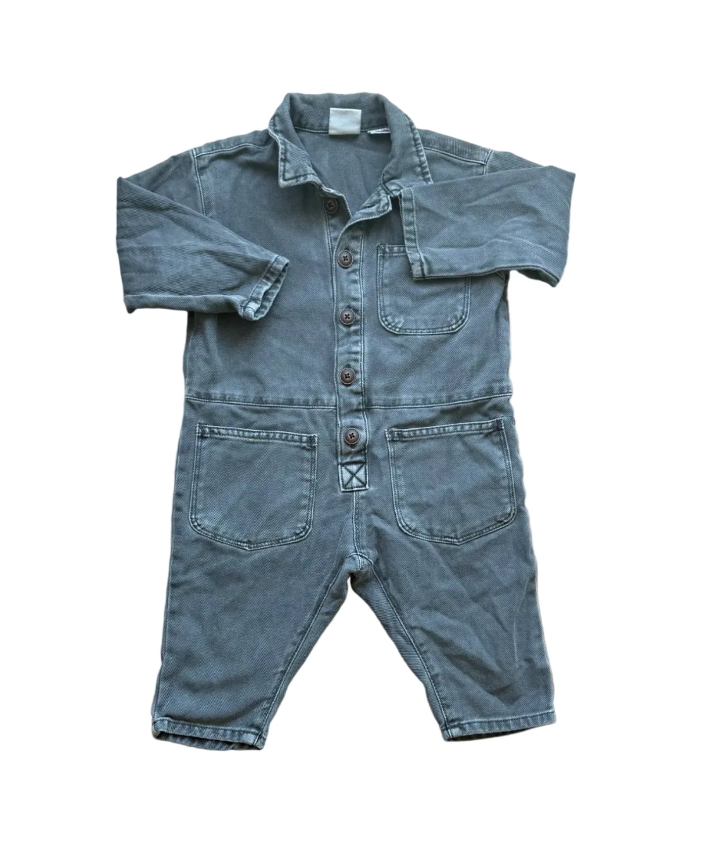 Une-pièce bébé en denim bleu clair, manches longues, boutonnage et poches