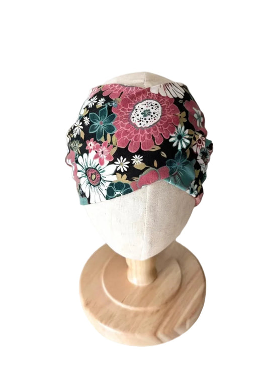 Bandeau bébé floral noir, rose et vert, ajusté et replié.