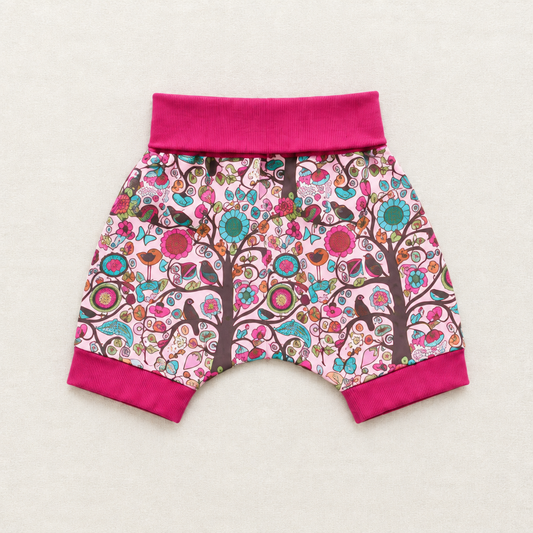 Short enfant à motif floral multicolore, ceinture élastique fuchsia.